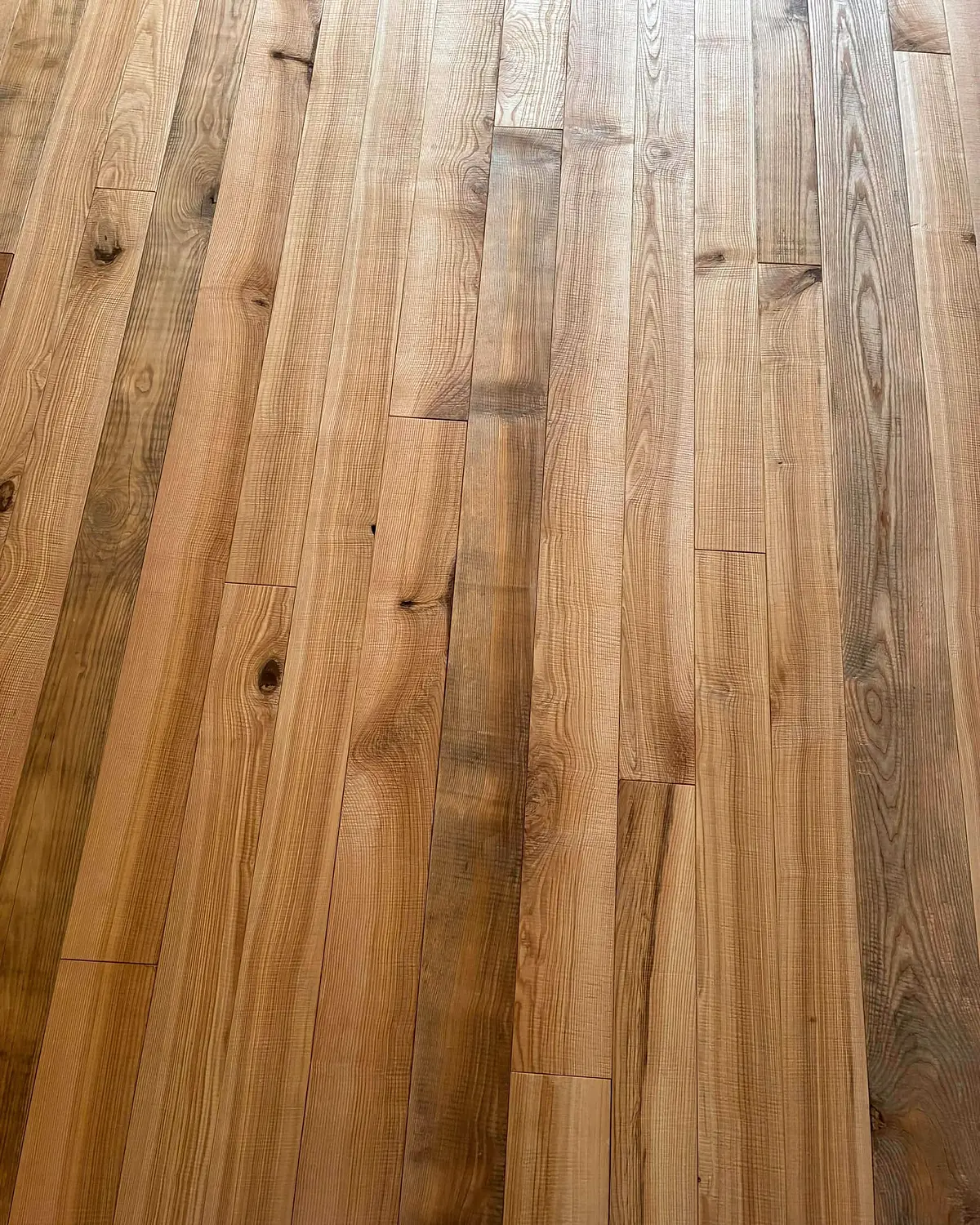 Detail kresby a odstínových rozdílů dokončené olejované jasanové podlahy.